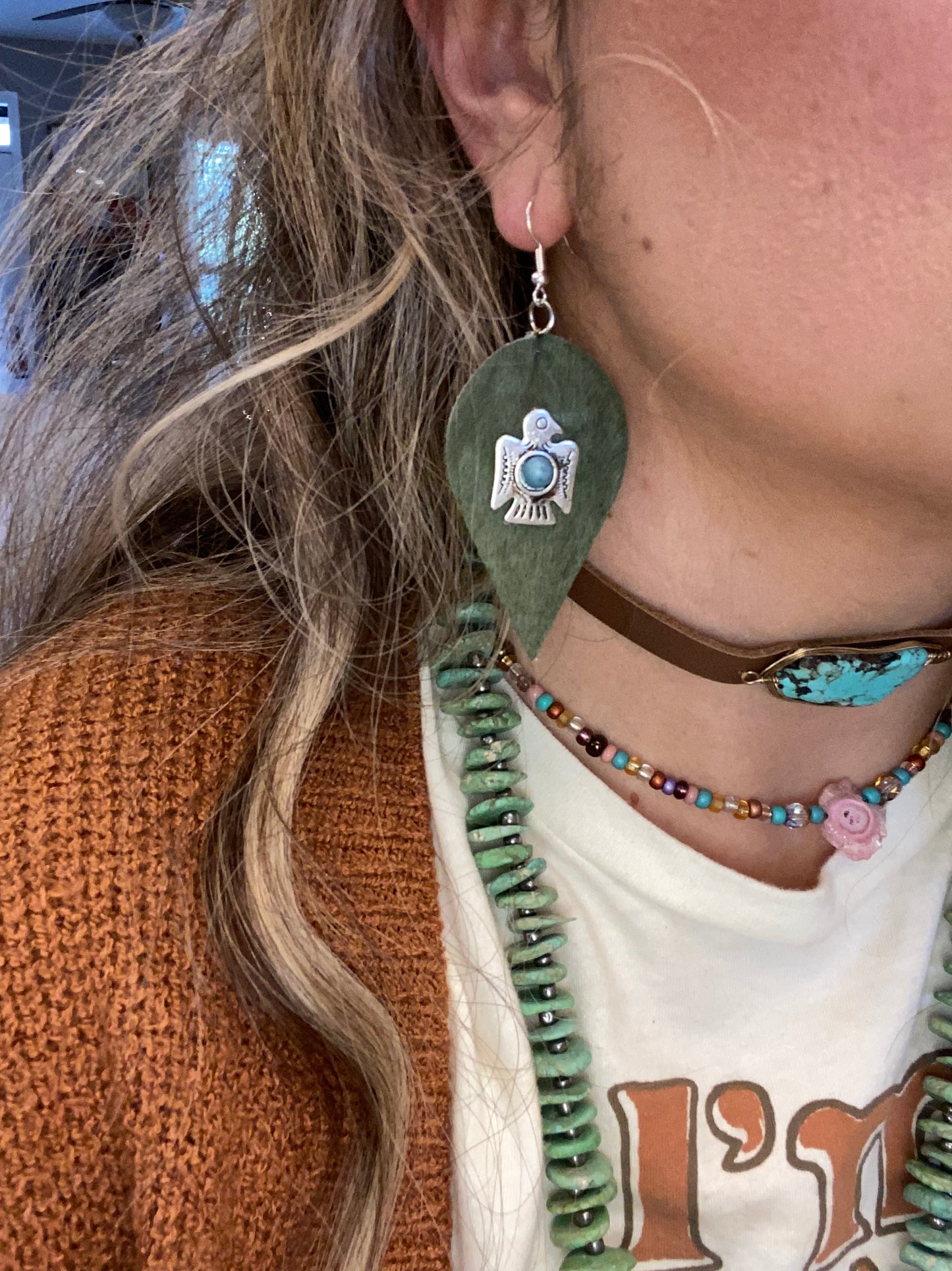 Green cowhide thunderbird with turquoise earrings